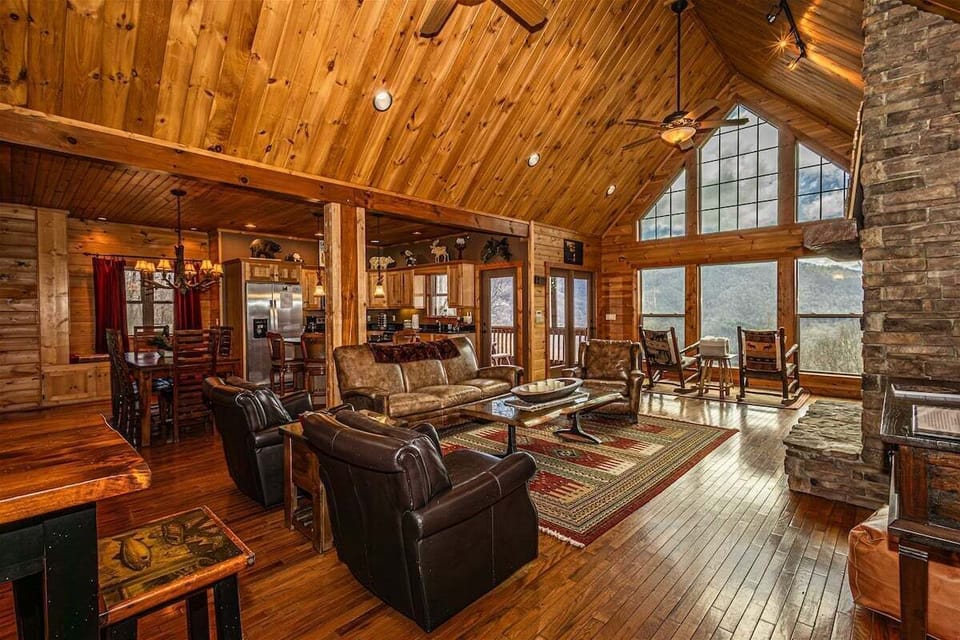 Wide view of the living and dining areas with expansive windows overlooking the mountains. The layout provides ample room for group gatherings.