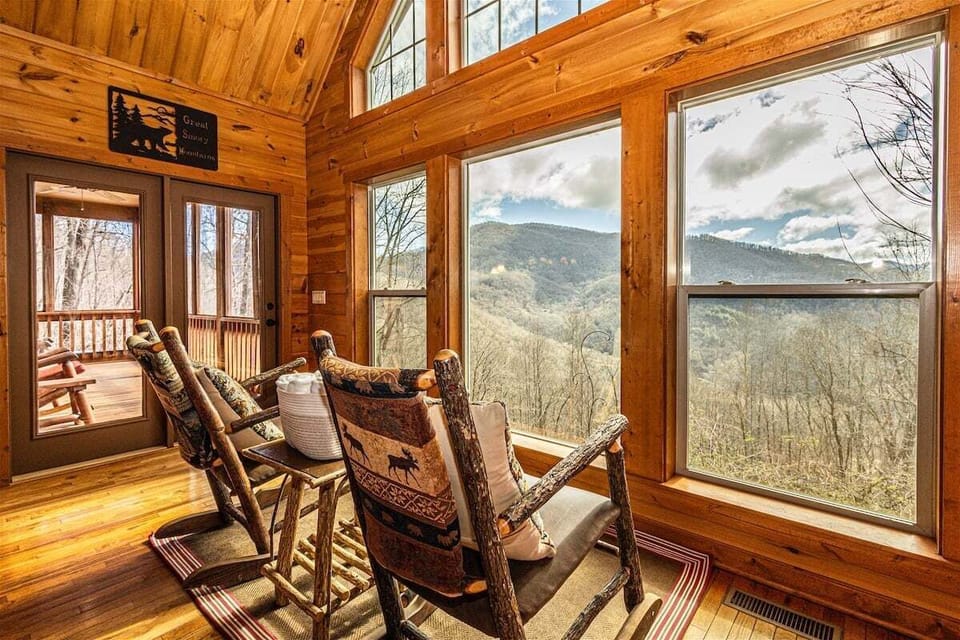 Interior seating area with large picture windows showcasing mountain views. Natural light fills the open-concept living space.