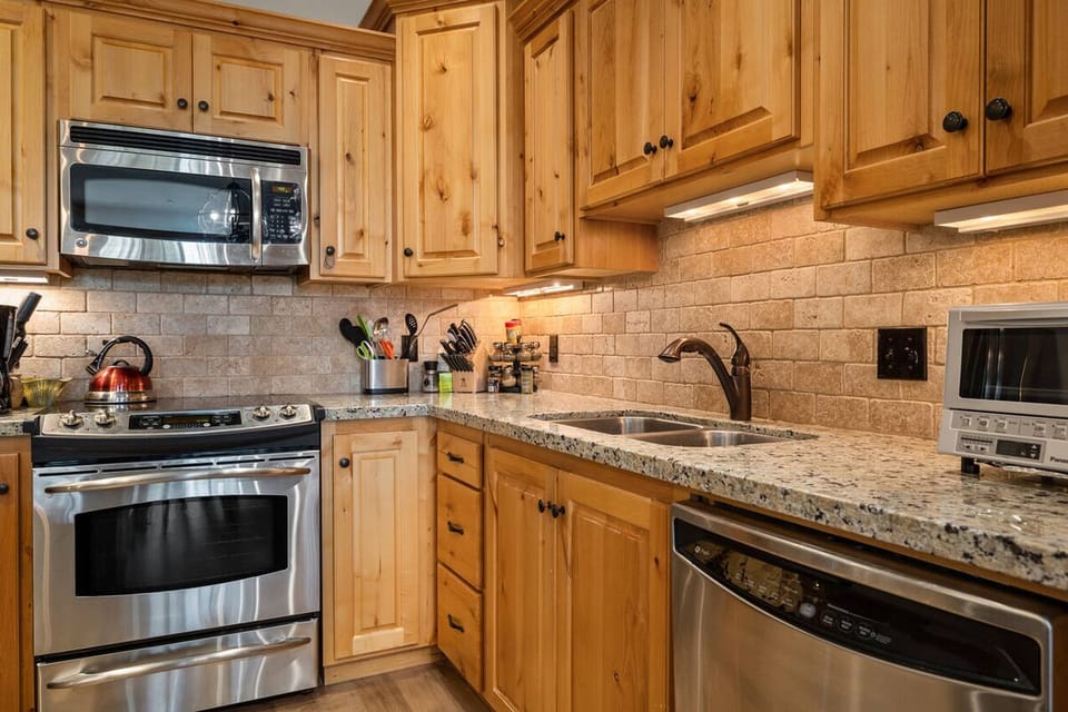 Prep dinner on granite counters with gleaming stainless appliances.