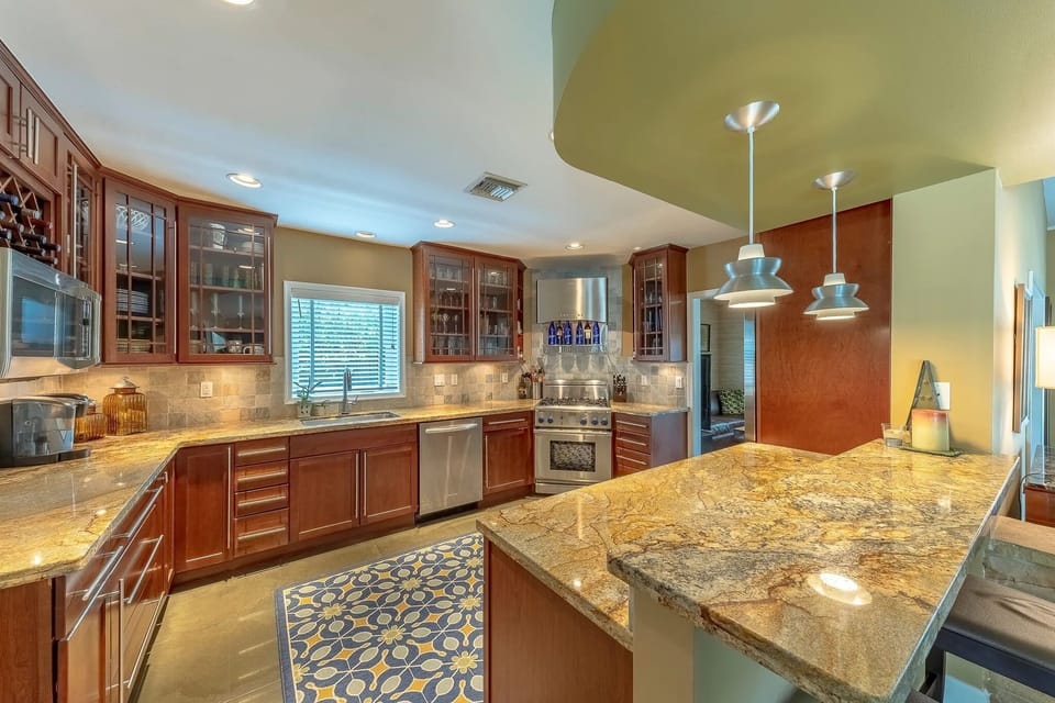 Open chef's kitchen with granite counters, bar seating, high end appliances