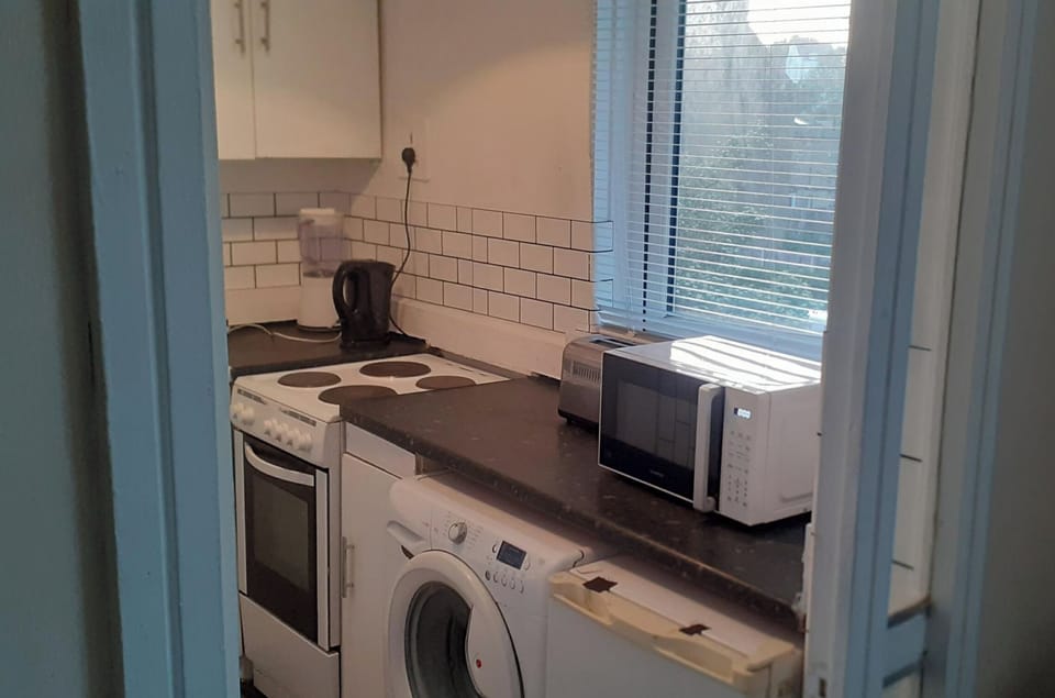 Kitchen with microwave kettle and cooker 


