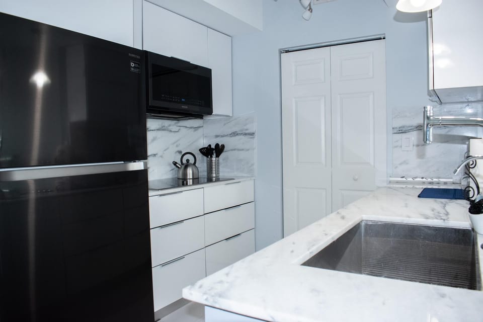 Modern kitchen with up to date stainless steel appliances and an electric stove.