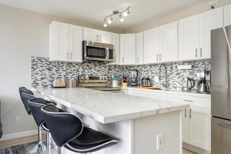 Quartz countertops with 4 adjustable height comfortable modern dining chairs.