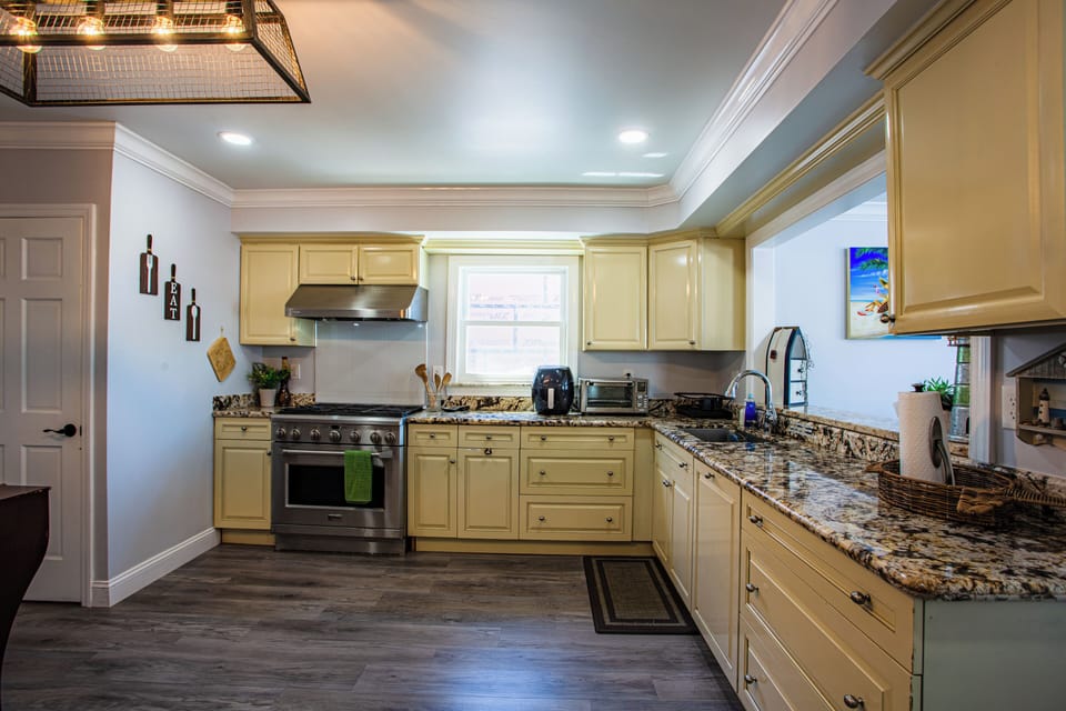 Bright gourmet kitchen with granite counters and stainless steel appliances