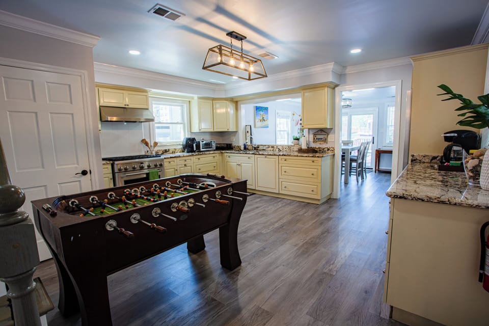 Bright gourmet kitchen with granite counters and a fun foosball table