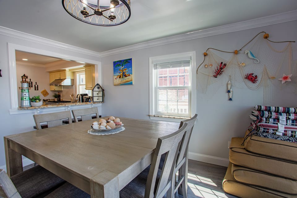 Bright coastal dining area with large table and easy kitchen access