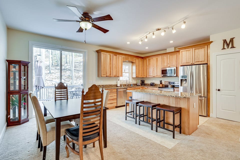 Kitchen with 3 bar stools and dining room
