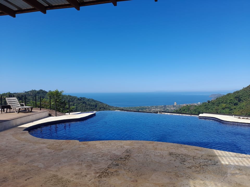 Infinity edge swimming pool adjacent to sun deck, BBQ bar and covered terrace!