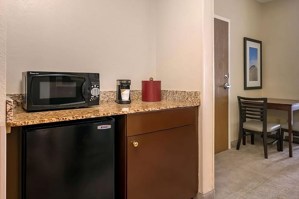 This unit comes with a mini-fridge, coffee maker, and a microwave!