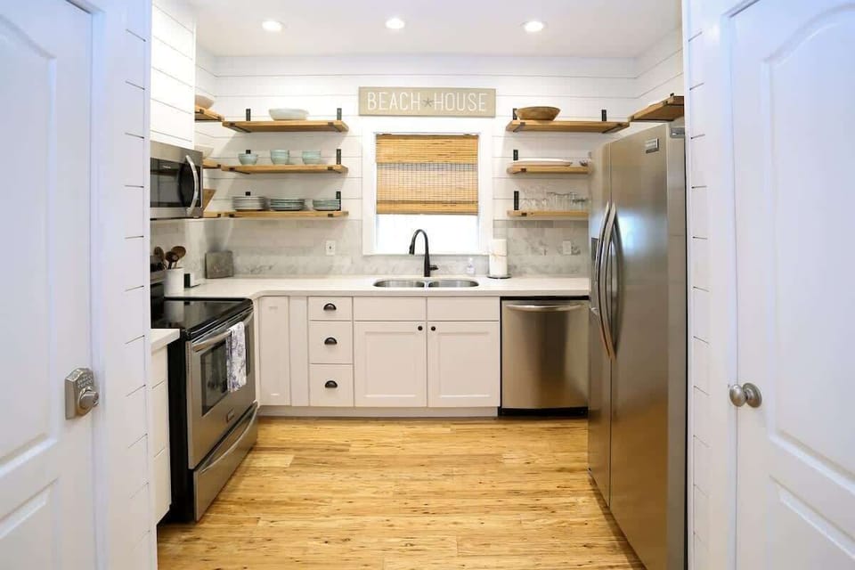 - Channel your inner chef in this fully equippped kitchen with open shelving and fresh style - Stocked with essentials, stainless appliances, and a beachy vibe up top - Welcoming space for morning brews or full family feasts with ease