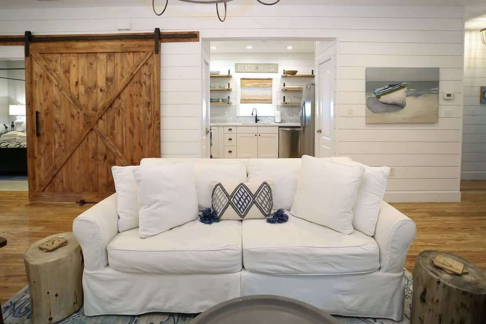 - Bright & breezy, this living space invites you to unwind in total comfort - Barn door adds a touch of rustic soul, while the open layout keeps everyone connected - Kick off your shoes, sink into the sofa, and let vacation mode take over