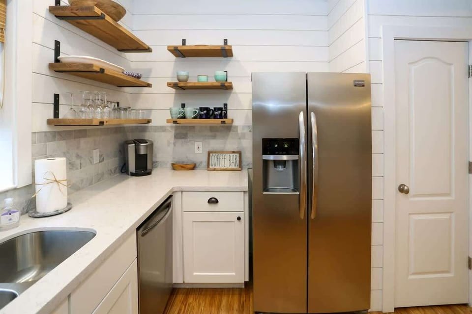 - Coastal charm meets practical comfort in this sleek, open shelf kitchen design - Stainless steel appliances, coffee bar vibes, and easy to reach essentials make mornings a breeze - Perfectly styled for  full meals, or late night cravings