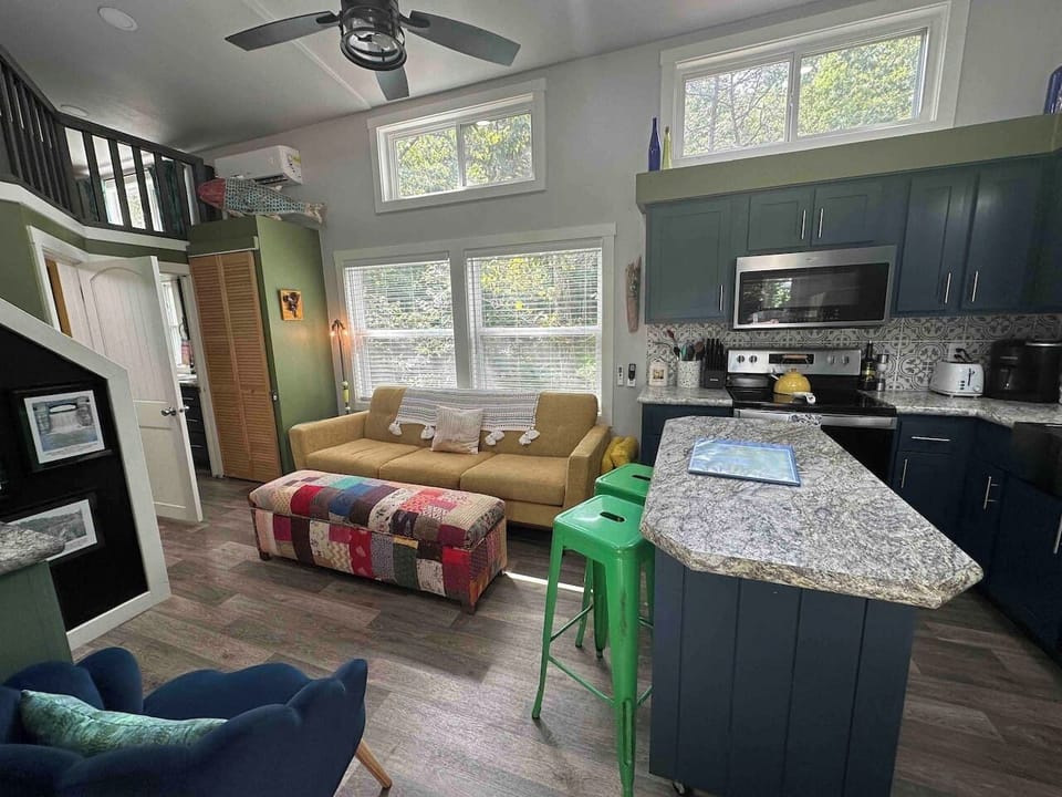 The living room and kitchen offer an open-concept layout with a Smart TV, modern appliances, and a bright, welcoming space to relax and gather.