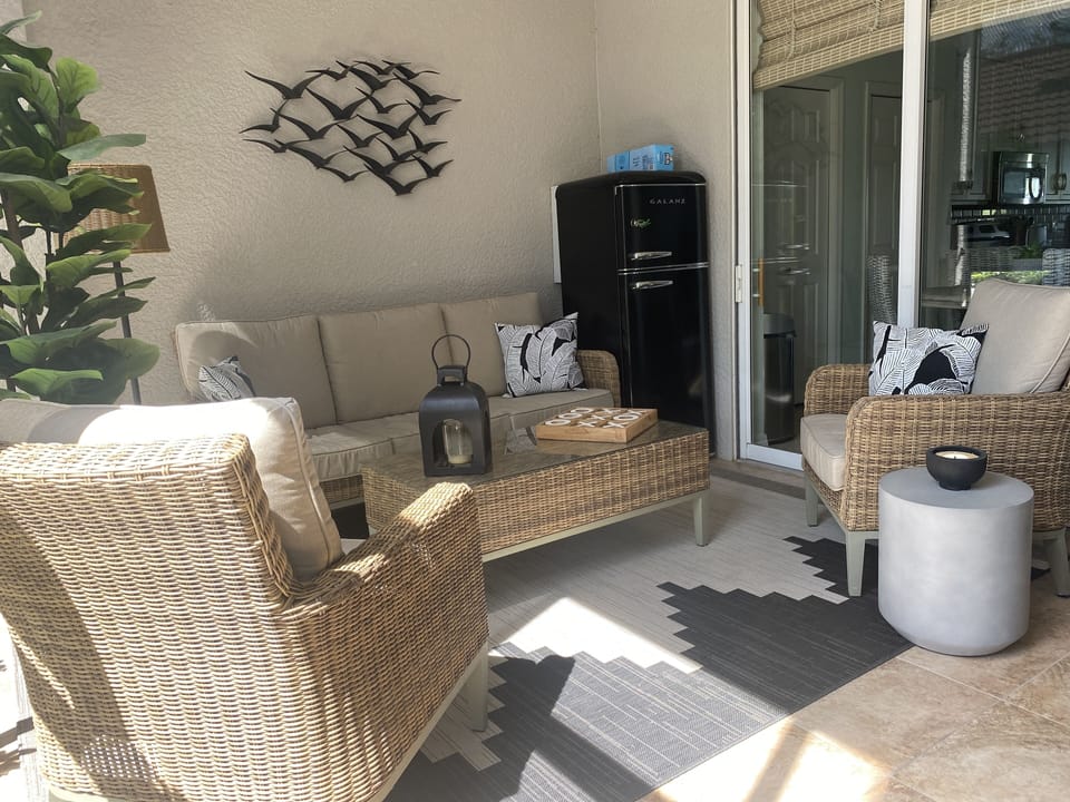 Front lanai with outdoor lamp, ceiling fan and beverage fridge.