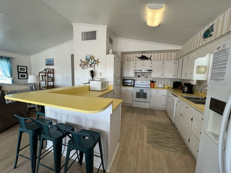 Your spacious kitchen invites culinary adventures with its bright island, full appliances, and charming coastal touches throughout.