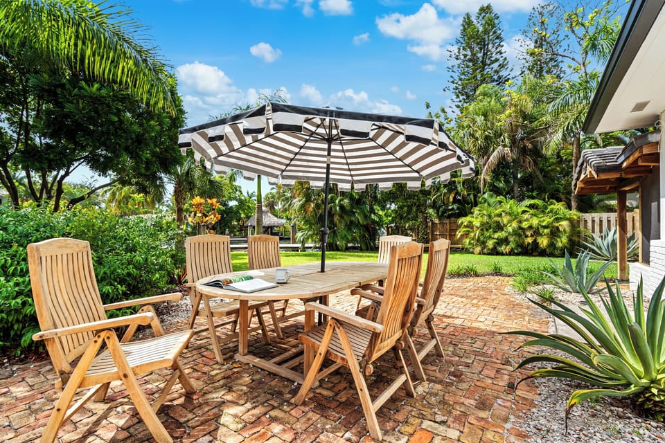 Outdoor teak dining table with umbrella and outdoor Grill