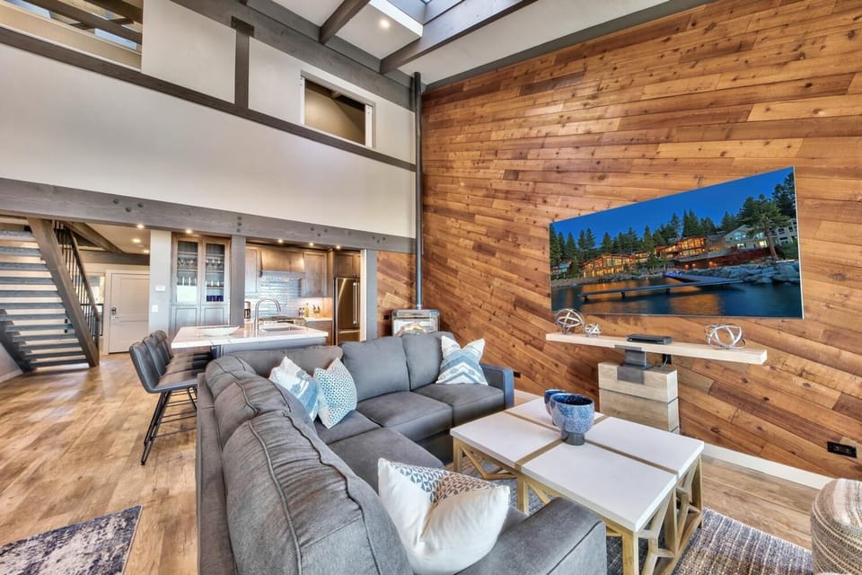 Relax in your spacious living room with soaring ceilings, warm wood walls, and modern comforts that invite you to unwind after mountain adventures.