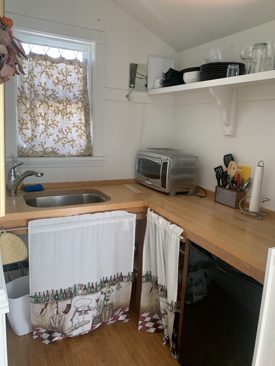 kitchenette with mini fridge, toaster oven, coffee maker, sink and hot plate.