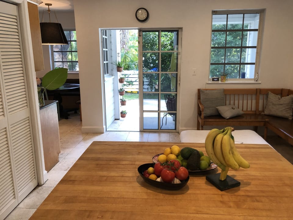 View from kitchen of sliding-door out to pool area and guest cottage