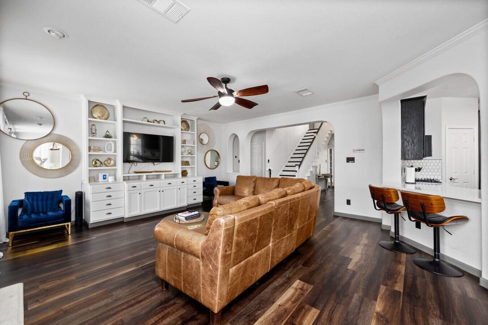 Spacious open living room with leather sectional, Smart TV, fireplace, and seating—perfect for relaxing together after a full day of fun.