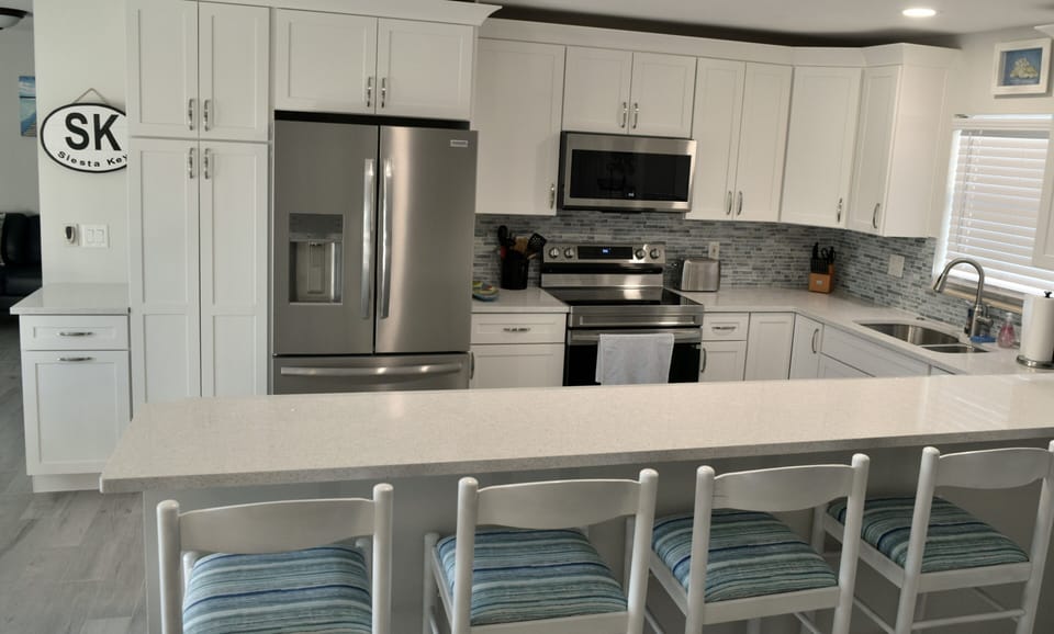 Notice the beach blue backsplash and beach inspired barstools.