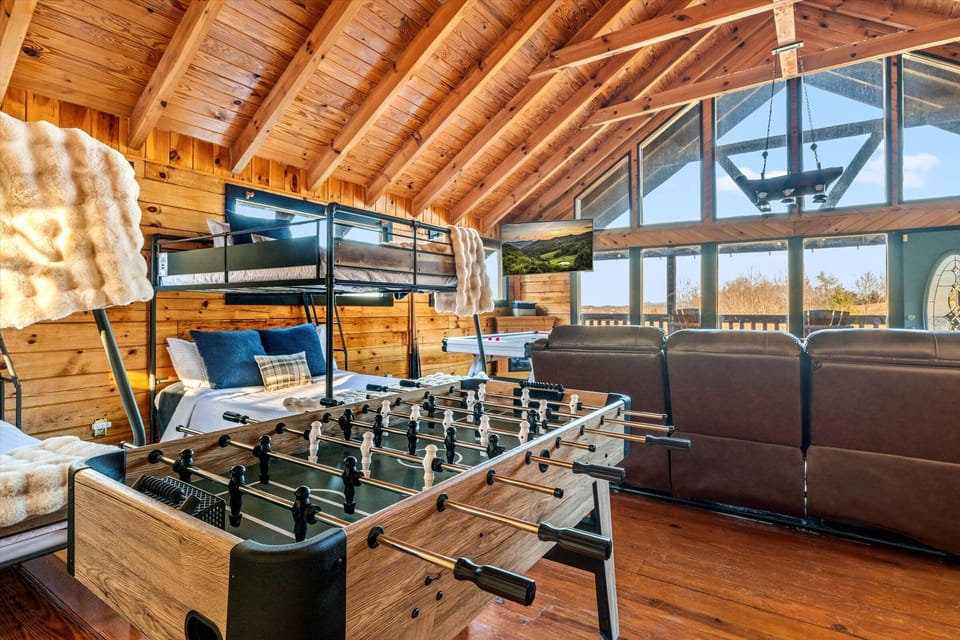 Game time downstairs with plenty of space for everyone to hang out, featuring pool, foosball, and big windows that bring the mountain views right inside.