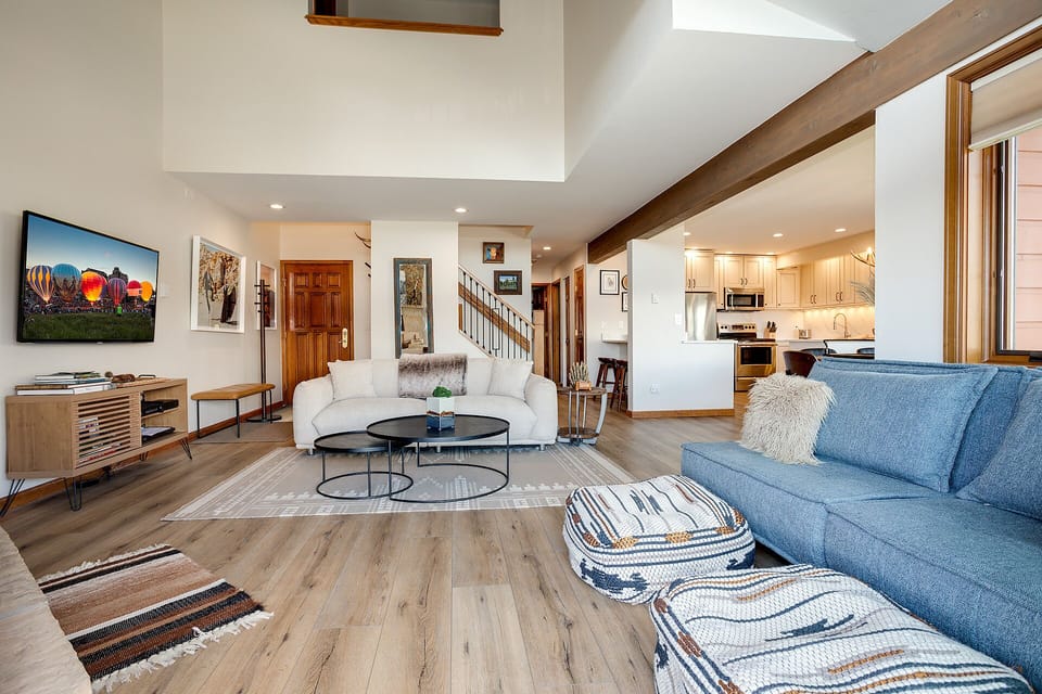 Unwind in this bright, open living space where modern comfort meets rustic charm with exposed beams and your fully equipped kitchen nearby.