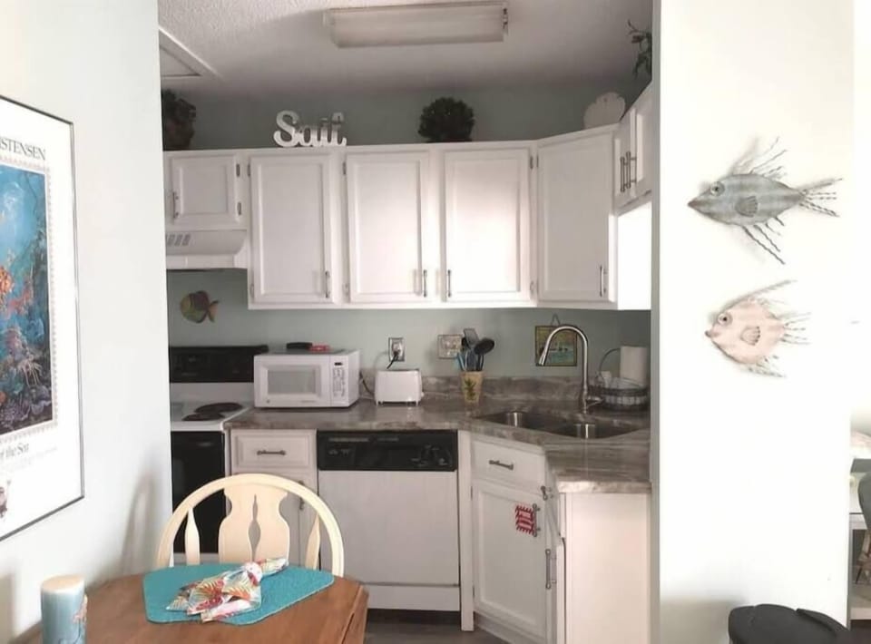 Full kitchen with cooking pots, pans, and utensils. Fold down leaf table seats four.