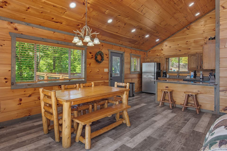 Gather around the handcrafted log table in your cozy cabin, where natural wood and forest views create the perfect spot for meals and making memories together.