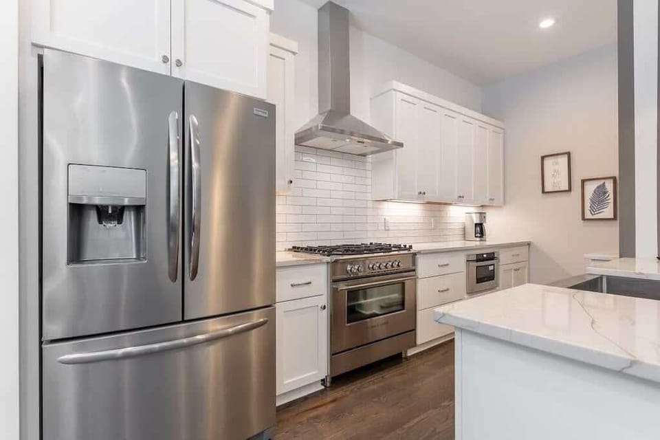 Sleek, bright kitchen featuring stainless steel appliances and elegant marble surfaces.