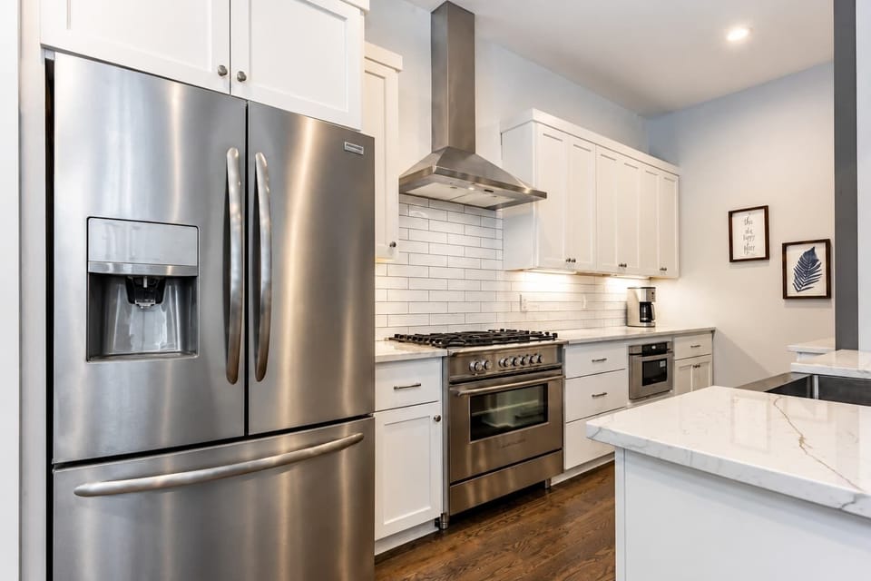 Sleek, bright kitchen featuring stainless steel appliances and elegant marble surfaces.