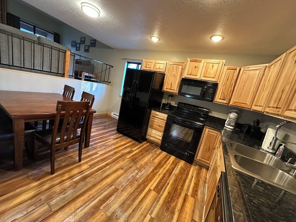 Spacious kitchen with pots, pans, dishes, glasses and coffee cups.