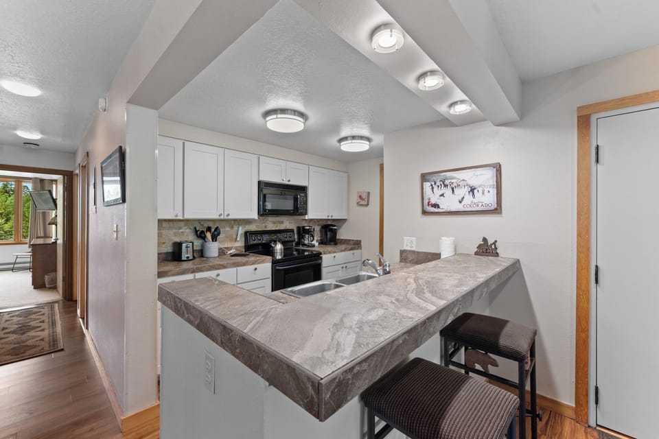 Full kitchen with breakfast bar seating 2.