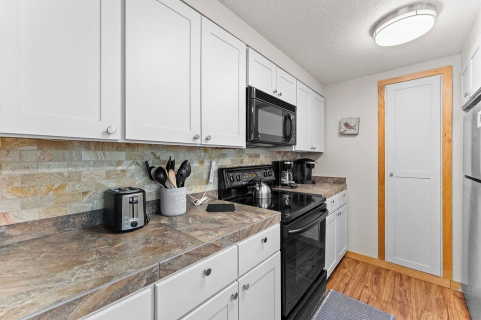 Full kitchen with breakfast bar seating 2.