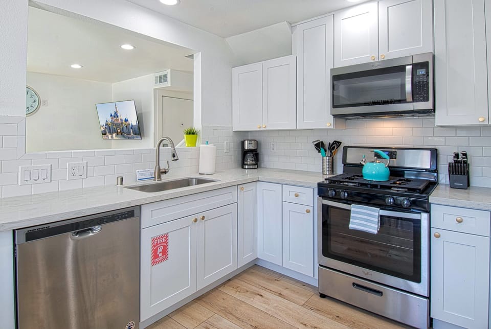 - Fully equipped kitchen with stainless steel appliances and essentials   - White cabinets and modern counters create a bright inviting space   - Perfect for cooking family meals during your vacation stay