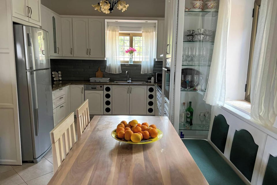 Fully equipped kitchen in the main villa featuring a dining space, stone arch detail, and easy access to the rest of the home.