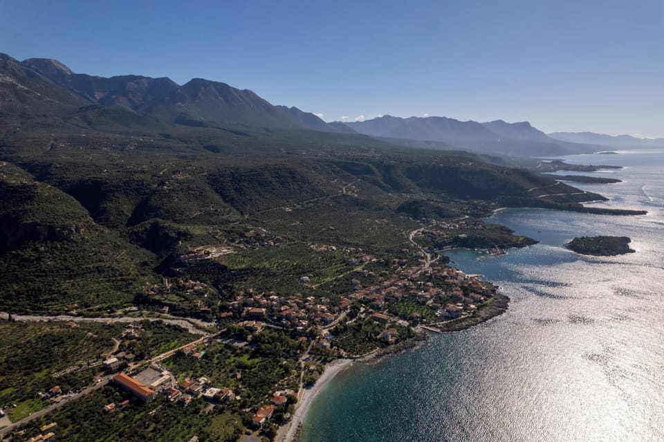 Aerial view of the town of Kardamili, showing the coastline, village center, and mountain backdrop along the Mani peninsula.