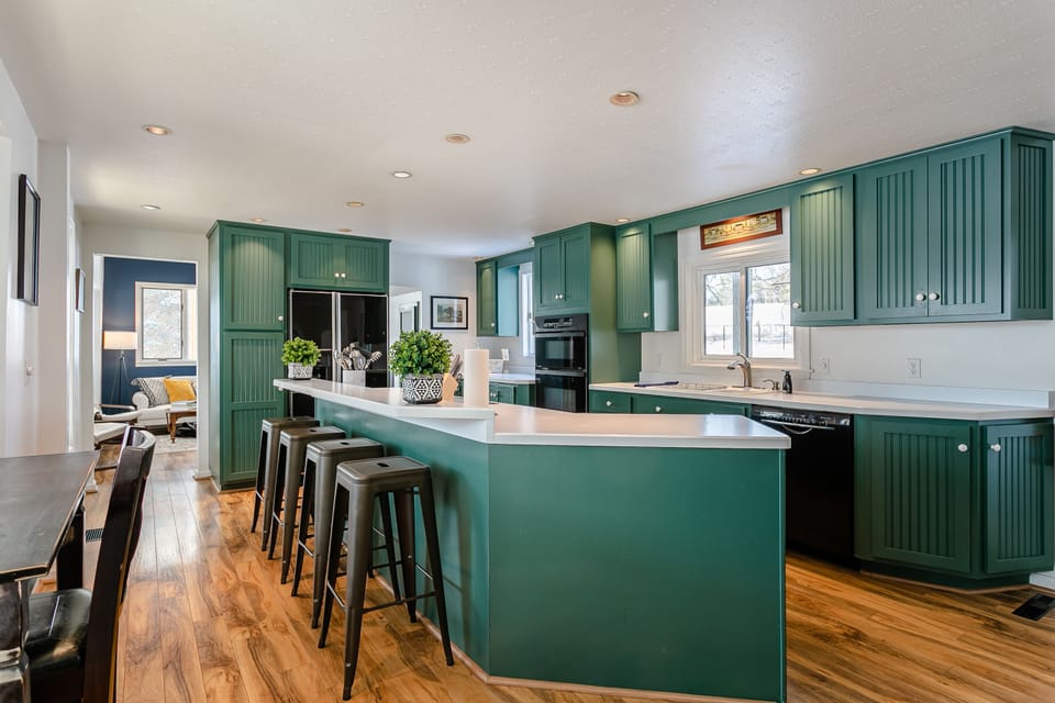 Large, fully stocked kitchen includes microwave, oven, stove, fridge, dishwasher, and laundry. Bar stools and counter-height table provide seating for 7.