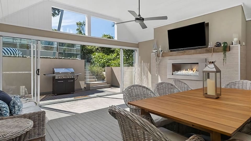 Discover a delightful covered outdoor area, thoughtfully designed with a comfortable table for outdoor meals. On chilly evenings, gather around the mesmerizing gas log fire while the sliding doors allow you to bring the outside in.