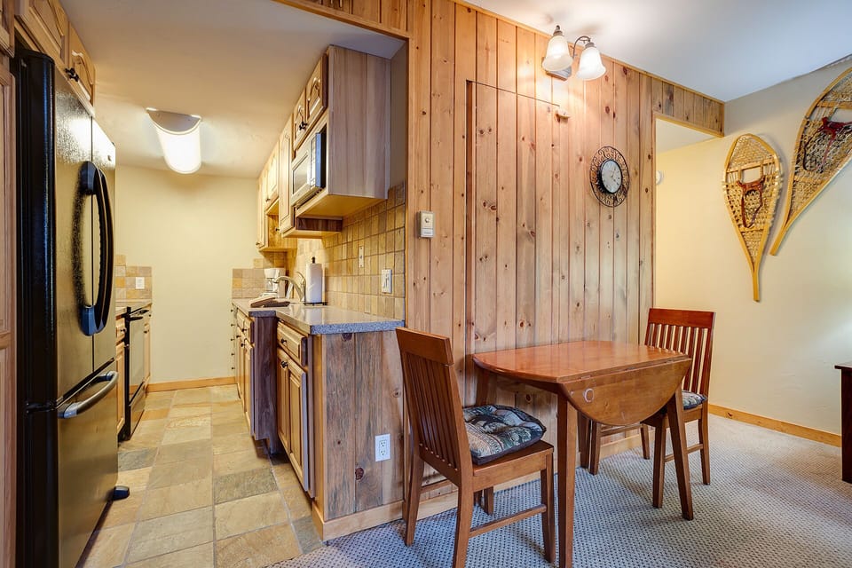 Your cozy mountain kitchen combines rustic pine walls with modern appliances, creating the perfect space for preparing memorable meals together.