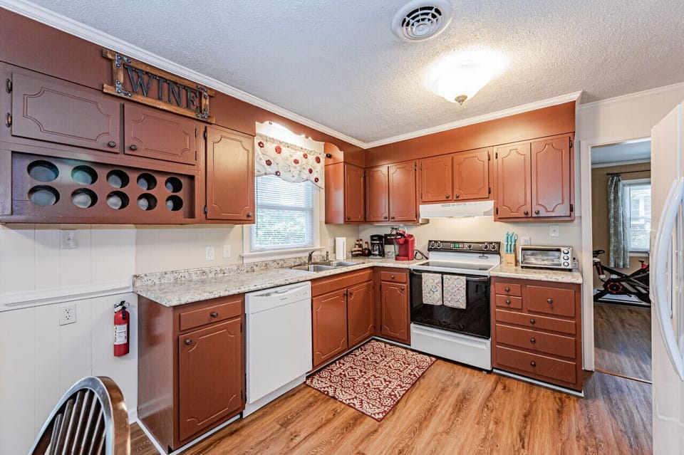 This refreshed kitchen features new floors, countertops, and upgraded appliances. A microwave, dishwasher, double‑basin sink, and wine rack add convenience, while the open flow to the dining area and backyard keeps everything convenient and comfy!