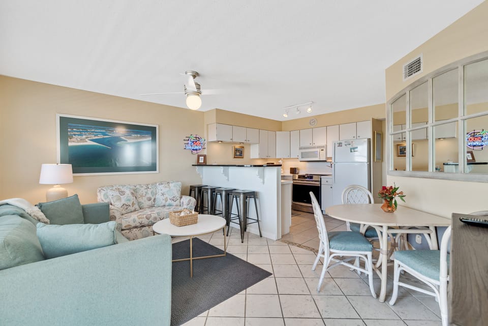 Designed for modern coastal living, this expansive open-concept area at Summer Breeze offers a welcoming space where everyone can connect. From preparing meals in the kitchen to relaxing in the living room, guests can enjoy each other's company with ease.