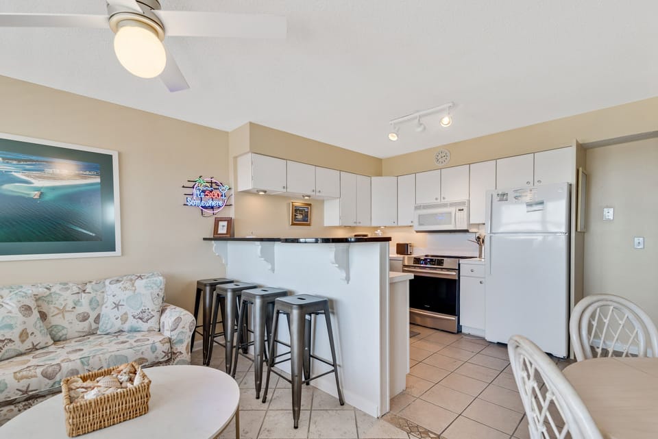 Gather, cook, and relax all in one bright, inviting space. Our open-concept living, dining, and kitchen area at Summer Breeze Condominiums is ideal for creating memorable moments, offering both convenience and comfort throughout your vacation.