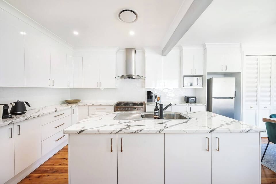 The open plan kitchen features an island bench with a butlers pantry as well as contemporary appliances for gourmet meals at home.