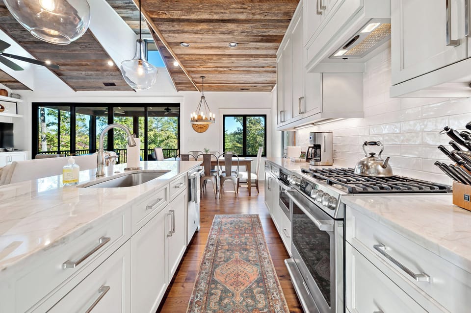 Luxury kitchen with bar seating, gas range, dishwasher, and drip-style coffeemaker.