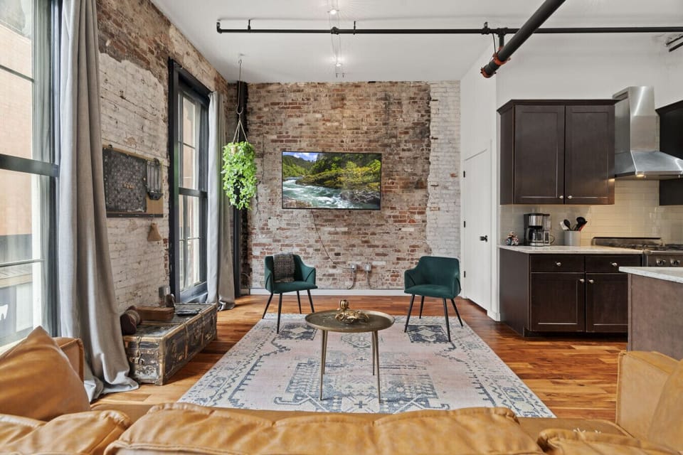 Bright living space with chic décor, exposed brick, and the newly upgraded smart TV.