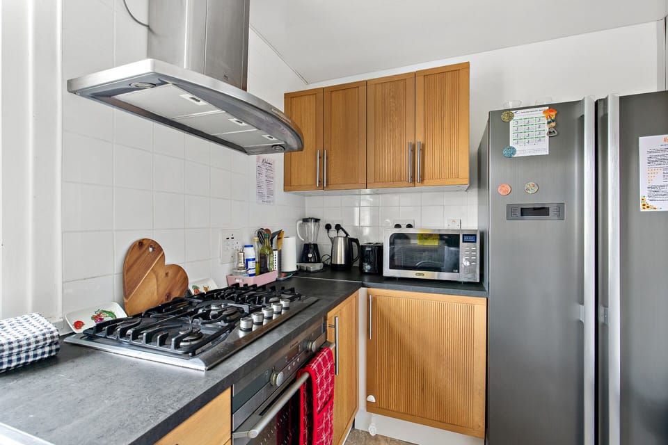 Kitchen equipped with fridge, microwave,  oven, hob