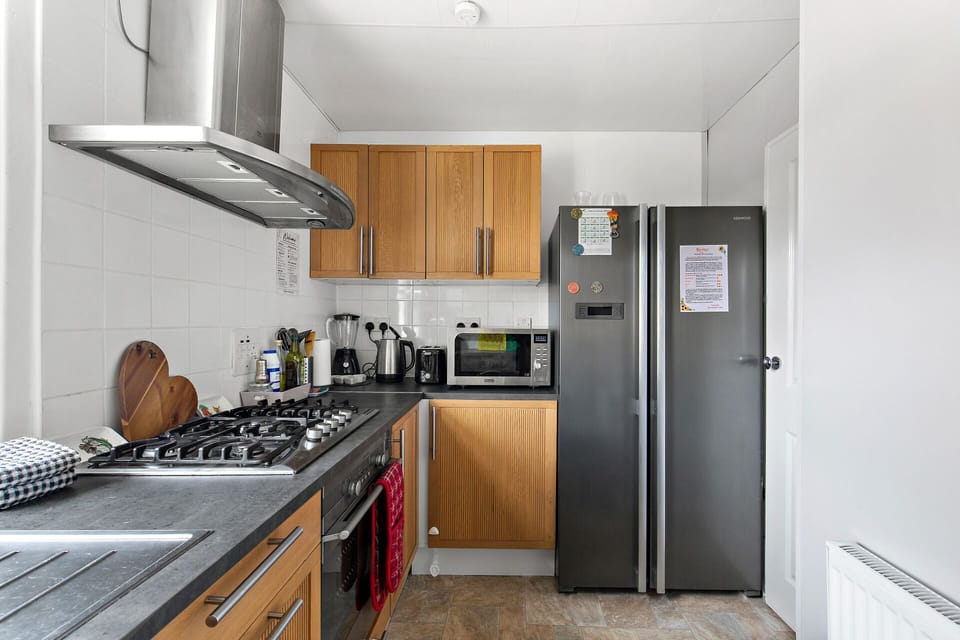 Kitchen equipped with fridge, microwave,  oven, hob