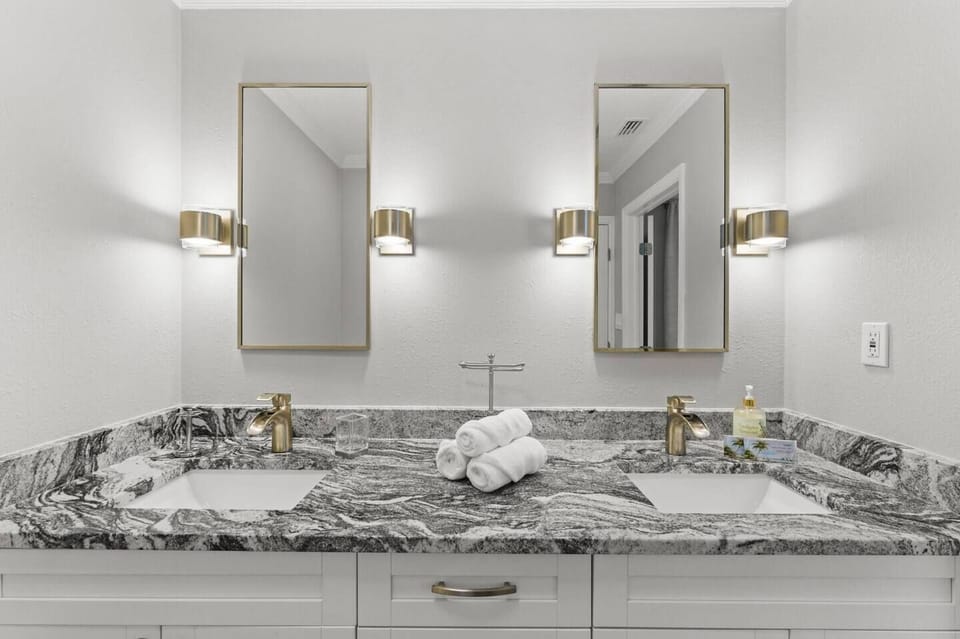 The private en suite bathroom features a walk-in shower, double vanity with granite countertops, and a luxurious ambiance.