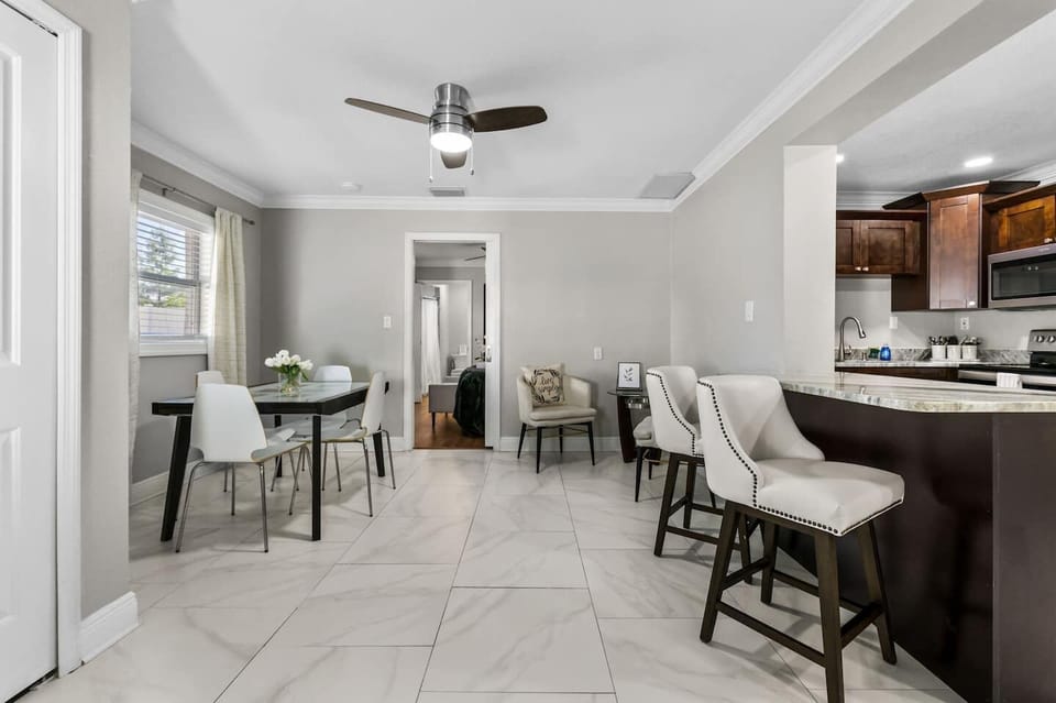 The kitchen flows seamlessly into the dining area, featuring a table for four, bar top seating for two, and a cozy nook perfect for morning coffee, reading a book, or simply unwinding.